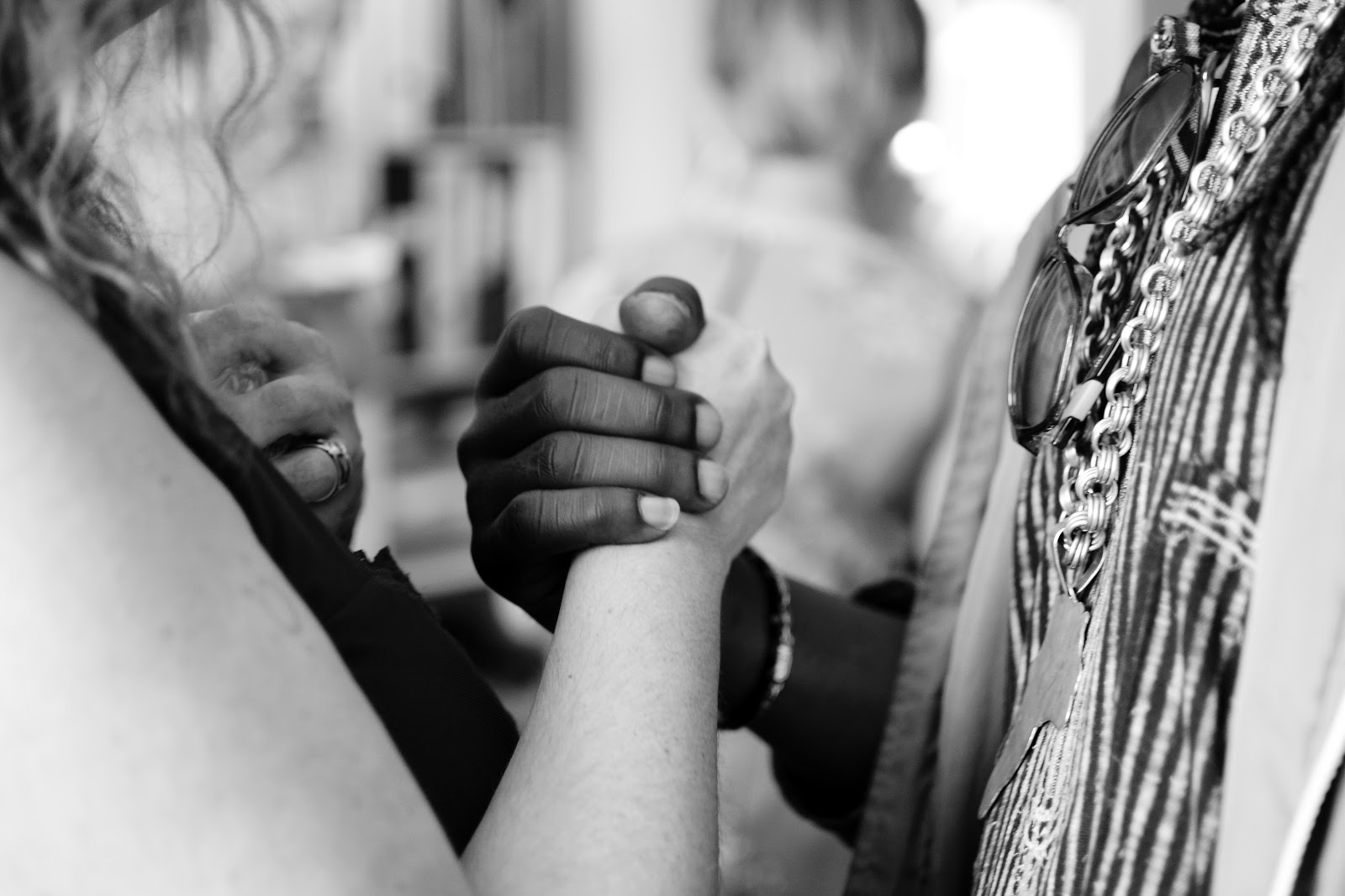 A White woman and Black woman hold hands in solidarity with the Black Lives Matter movement