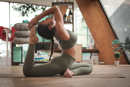 A woman practices king pigeon pose for her yoga practice to prepare for life after quarantine